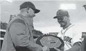  ??  ?? Red Sox manager Alex Cora, left, presents right fielder Mookie Betts with the 2018 AL MVP Award in April 2019.
