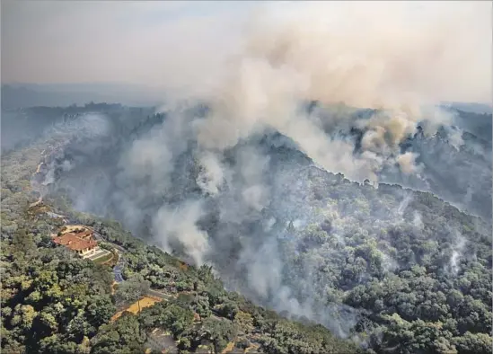  ?? Marcus Yam Los Angeles Times ?? THE TUBBS FIRE moves up Shiloh Ridge toward a home near Santa Rosa on Wednesday. The fire was one of 16 burning in Northern California, where at least 23 people were killed as the blazes scorched an estimated 170,000 acres and destroyed 3,500...