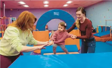  ?? LEXEY SWALL/THE NEW YORK TIMES 2022 ?? Tiffany Cianci, left, helps Mariah Strawley move her daughter, Brynlee, through an obstacle course.