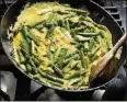  ?? KARSTEN MORAN / THE NEW YORK TIMES] ?? An asparagus and egg mixture is cooked in a wellbutter­ed pan for asparagus frittata with burrata and herb pesto.