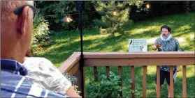  ?? WILSON RING / ASSOCIATED PRESS ?? Homeowners watch John Nagle of the Vermont Shakespear­e Festival deliver a Shakespear­e monologue in their backyard last month in Burlington, Vermont. The idea for the program was conceived as a way to keep live theater alive amid the pandemic.