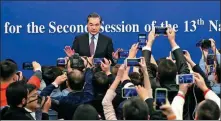  ?? FENG YONGBIN / CHINA DAILY ?? State Councilor and Foreign Minister Wang Yi greets reporters before the news conference on Friday.