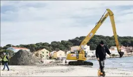  ?? (Photo Sophie Louvet) ?? La pelleteuse, avec son bras de  mètres, fait des tas de sable tous les  mètres sur la plage.