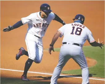  ?? SEAN M. HAFFEY/GETTY IMAGES ?? George Springer of the Houston Astros celebrates with third base coach Omar Lopez after hitting a homer against the Tampa Bay Rays to open the scoring on Thursday in Game 5 of the ALCS.