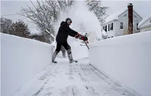  ?? AP Photo/Craig Ruttle ?? Linda Marzell of Binghamton, N.Y., clears a sidewalk using a snowblower after a heavy snowfall Thursday in Binghamton, N.Y. Binghamton Airport reported 39.1 inches of snow and another spot in the area reported 41.0 inches, according to the National Weather Service.