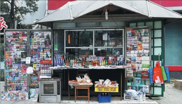  ?? WANG JING / CHINA DAILY ?? This newsstand in Chaoyang district, Beijing, is one of the few remaining in the city. Many have closed because of falling demand for newspapers and magazines.