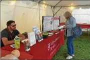  ??  ?? Guilderlan­d resident Marie Provost gets some informatio­n about Alzheimer’s disease during the fair Friday.