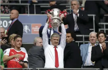  ?? AP PHOTO/MATT DUNHAM ?? ABOVE RIGHT: Arsenal team manager Arsene Wenger lifts the trophy after winning the English FA Cup final soccer match between Arsenal and Chelsea at the Wembley stadium in London on Saturday.