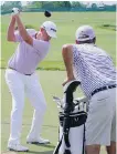  ??  ?? Davis Love III watches his son, Davis Love IV, hit on the range Wednesday at Erin Hills.