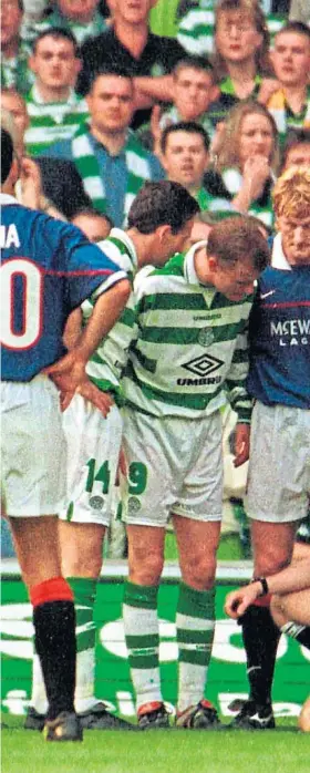  ??  ?? Celtic and Rangers players show their concern for referee Hugh Dallas a