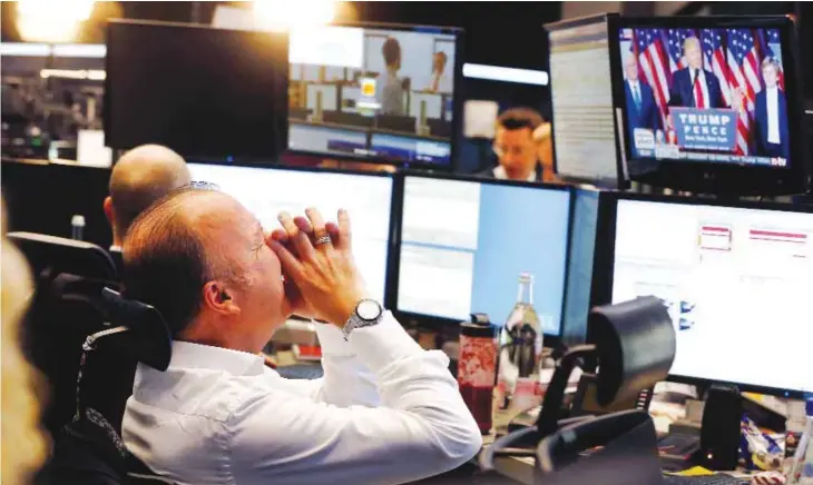  ??  ?? FRANKFURT: In this Wednesday, Nov 9, 2016 file photo, a broker reacts as US President-elect Donald Trump appears on a television screen at the stock market. — AP