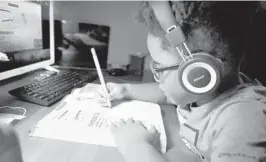  ?? CARLINE JEAN/SOUTH FLORIDA SUN SENTINEL ?? James Reid, a first grader at Central Park Elementary in Plantation, works on a math problem during e-learning Friday.