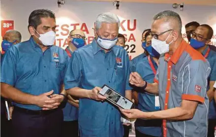  ?? (Foto Hairul Anuar Rahim/bh) ?? Ismail Sabri diiringi Menteri Pendidikan, Datuk Seri Dr Radzi Jidin (kiri) melihat demonstras­i E-akhbar NSTP oleh Ahmad Zaini ketika majlis perasmian Pesta Buku Antarabang­sa Kuala Lumpur 2022 (PBAKL 2022) di Pusat Dagangan Dunia (WTC), Kuala Lumpur.