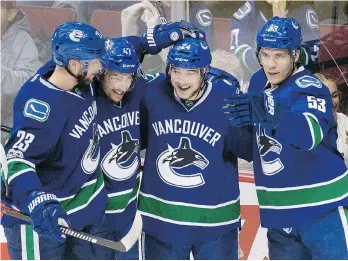  ?? JONATHAN HAYWARD/ THE CANADIAN PRESS ?? From left, Canucks centre Reid Boucher celebrates his goal against the Islanders on Thursday with Alexander Edler, Sven Baertschi and Bo Horvat.