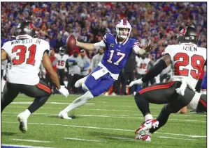  ?? (AP/Jeffrey T. Barnes) ?? Buffalo Bills quarterbac­k Josh Allen (17) scrambles past Tampa Bay Buccaneers safety Antoine Winfield Jr. (31) and safety Christian Izien (29) for a touchdown Thursday in Orchard Park, N.Y. Allen ran for a touchdown and threw two more in a 24-18 Bills victory.