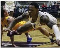  ?? Arkansas Democrat-Gazette/MITCHELL PE MASILUN ?? UALR guard Rayjon Tucker (right) and Southeaste­rn Oklahoma State guard Adam Dworsky fall to the floor Thursday after Tucker was called for a charging foul during the Trojans’ 101-92 overtime victory at the Jack Stephens Center.