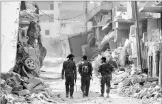  ??  ?? Members of the Syrian Democratic Forces walk in the former Islamic State stronghold of Raqa, as the Syrian fighters backed by US special forces battle to clear the last remaining jihadists holed up in the city. — AFP photo