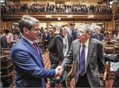  ?? BOB ANDRES / BANDRES@AJC.COM ?? Gov. Brian Kemp (left) greets former U.S. Sen. Johnny Isakson as Kemp arrived to deliver his second State of the State address Thursday. The governor and House honored Isakson during the session.