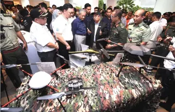  ??  ?? Dr Mahathir (third left) listens to a briefing at the exhibition launch. — Bernama photo