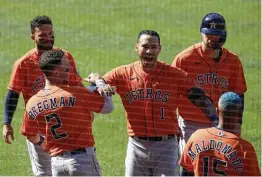  ?? Harry How / Getty Images ?? Carlos Correa, center, one of the few Astros off to a slow start, takes his turn in a starring role Tuesday with a two-run, tiebreakin­g homer in the ninth inning.