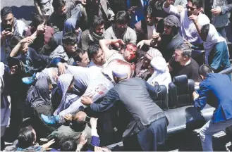  ?? HEDAYATULL­AH AMID/EUROPEAN PRESSPHOTO AGENCY ?? Demonstrat­ors in Kabul carry a man injured during a protest decrying the huge truck bombing that killed more than 100 in the capital Wednesday. “This government cannot protect us,” said a protester.