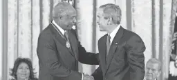  ??  ?? President George W. Bush presents the Presidenti­al Medal of Freedom to baseball legend Frank Robinson in the East Room on Nov. 9, 2005.