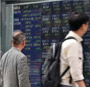  ?? [FOTO AFP] ?? Nikkei Tokyo susut 1.3 peratus dengan lonjakan yen selepas pasaran kembali dari hujung minggu yang panjang.