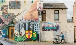  ?? ANDREW TESTA/THE NEW YORK TIMES ?? Sinn Fein campaign posters and a Republican mural reflect political sentiment on Falls Road, a Catholic stronghold in Belfast, Northern Ireland.