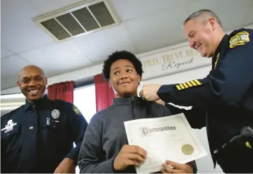  ?? STEPHEN M. KATZ/STAFF PHOTOS ?? Virginia Beach Police Chief Paul Neudigate places a pin on Tayten Smith’s collar during Saturday’s ceremony for the first Kids Law Academy.