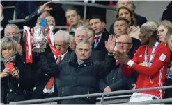  ??  ?? LONDON: Manchester United’s Portuguese manager Jose Mourinho holds up the trophy as Manchester United players celebrate their victory after the English League Cup final football match between Manchester United and Southampto­n at Wembley stadium on...