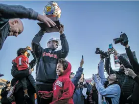  ?? JIM WEBER ?? Fresno State interim coach Lee Marks hoists the New Mexico Bowl trophy while bowl executive director Jeff Siembieda, left, celebrates with the coach’s son Saturday.