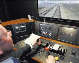  ?? Damian Dovarganes ?? The Associated Press Director of Operations R.T. Mccarthy demonstrat­es Metrolink’s implementa­tion of Positive Train Control at the Metrolink Locomotive and Cab Car Simulators training facility in Los Angeles’ Union Station.