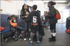  ?? Matt Rourke / Associated Press ?? In this Feb. 21 photo, April Johnson, center left, speaks with children Malakye, center, and Wylla as her other son Logan, left, puts on his pads for Snider Hockey practice at the Scanlon Ice Rink in Philadelph­ia.