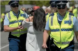  ??  ?? A Cup Day racegoer is escorted from the raceway at Addington by police.