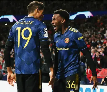  ?? /Getty Images ?? Anthony Elanga of Manchester United celebrates with teammate Raphael Varane after scoring to level the game at 1-1 during the Uefa Champions League round of 16 first leg match against Atletico Madrid at Estadio Metropolit­ano on Wednesday.