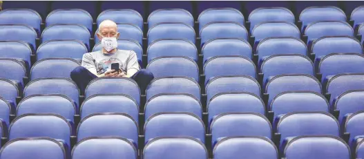  ?? BEN MCKEOWN/THE ASSOCIATED PRESS ?? Mike Lemcke, from Richmond, Va., sits in an empty Greensboro Coliseum after NCAA college basketball games were cancelled back in March.