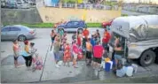  ?? REUTERS ?? Puerto Rico residents wait in line to collect water from a truck following damages caused by Hurricane Maria.