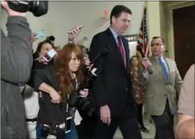  ?? SUSAN WALSH — THE ASSOCIATED PRESS ?? Former FBI Director James Comey is followed by reporters on Capitol Hill in Washington, Friday following his appearance before a closed-door hearing with the House Judiciary and House Oversight committees.