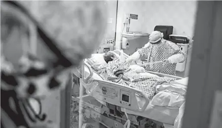  ?? JOHN MINCHILLO/AP ?? Resident physician Leslie Bottrell stands outside a room at a Yonkers, New York hospital as a nurse suctions the lungs of a patient with COVID-19.