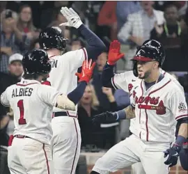  ?? Robert Gauthier Los Angeles Times ?? EDDIE ROSARIO, right, celebrates with Ozzie Albies after hitting a three-run homer during Game 6. Rosario had three homers and nine RBIs in the NLCS.