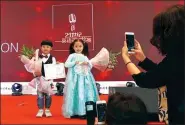  ?? GAO ERQIANG / CHINA DAILY ?? Parents take pictures of Yuan Youzhe (left) and Huang Yichen on the stage, after they won awards at the competitio­n.