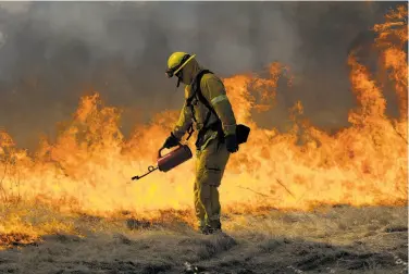  ?? Sarahbeth Maney / Special to The Chronicle ?? A firefighte­r spreads a wall of flames during a training on controlled burns, a wildfire prevention tactic.