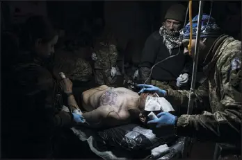  ?? EVGENIY MALOLETKA — THE ASSOCIATED PRESS ?? Ukrainian military medics treat a wounded comrade at a field hospital near Bakhmut, Ukraine, on Wednesday.