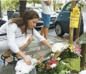  ?? CHIARA GABRIELLI/AP ?? A mourner places a bouquet of flowers Saturday where Nigerian street vendor Alika Ogorchukwu, 39, was beaten and killed in Civitanova Marche, Italy.