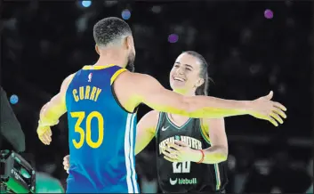  ?? Darron Cummings
The Associated Press ?? Warriors guard Stephen Curry hugs Liberty guard Sabrina Ionescu after beating her 29-26 on Saturday in the Steph vs. Sabrina competitio­n in Indianapol­is.