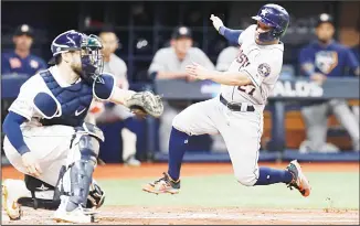  ??  ?? Houston Astros’ Jose Altuve, (right), heads for home, but is tagged out by Tampa Bay Rays catcher Travis d’Arnaud during
the fourth inning of Game 4 of a baseball American League Division Series on Oct 8, in St Petersburg, Fla.