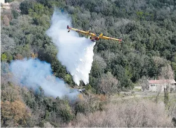  ??  ?? Des véhicules ont été ensevelis sous la neige dans les Alpes françaises alors que le risque d’avalanche était maximal, hier. Sur la photo du bas, des Canadair étaient en action en Corse afin d’éteindre les incendies causés par les vents violents et...