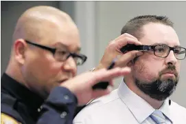  ?? MIKE BROWN/THE COMMERCIAL APPEAL ?? Interim Police Director Mike Rallings shows different ways police body cameras can be worn on Officer D. Evans during a presentati­on to a Memphis City Council committee. Mayor Jim Strickland said the cameras’ rollout date is still uncertain.