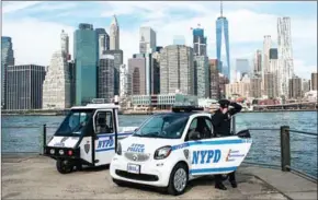  ?? CHRISTIAN HANSEN/THE NEW YORK TIMES ?? A new NYPD Smart car sits next to one of the older three-wheeled scooters, in New York, on October 13.