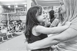  ??  ?? Sarah Slavin, holding her daughter, Elene, 3, attends family day at Vacation Bible School. VBS was one of the beloved church events led by Karla Holcombe, Sarah’s mother.